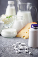 Fototapeta na wymiar Healthy and Nature Concept: Calcium white tablet a good supplement for women bone ,In a white bottle incline with dairy products as a background