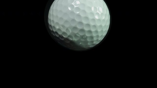 Golf. Ball games and sport. Individual golf balls spinning and tracking forwards towards the camera. Golf ball close up.