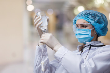 The doctor prepares a system for transfusion of infusion solutions .