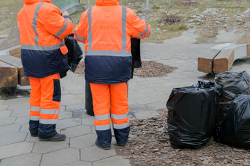 Workers clean up trash on the street.