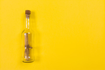 Message in bottle on yellow background with copy space for text