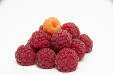 Red and one yellow of top raspberries, smooth pyramid, three by three, front view on a white background
