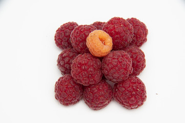 Red raspberries, smooth pyramid, three by three, top view on a white background