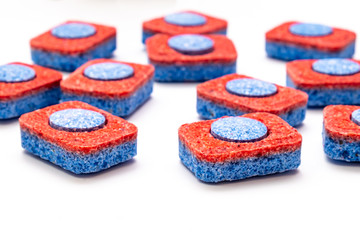 Many red and blue dishwasher soap tablets on white background, kitchen equipment and solutions for washing dishes, housekeeping concept