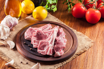 Raw fresh lamb chops on wooden cutting board