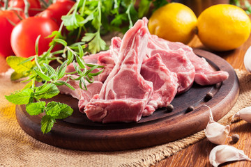 Raw fresh lamb chops on wooden cutting board