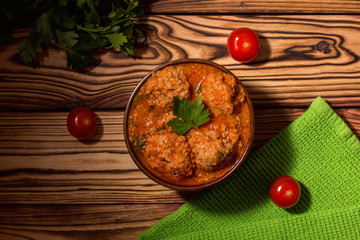 Meatballs with tomato sauce and parsley on wooden background. Keto diet food. Ketogenic.