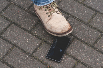 The man stepped on a cell phone and damaged the glass. Hacked mobile phone.