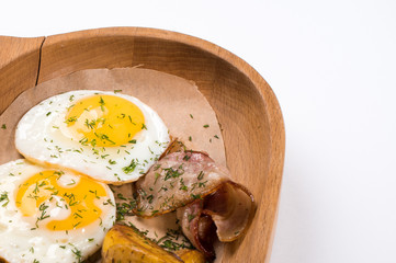 Fried eggs with bacon, potatoes and bread for breakfast