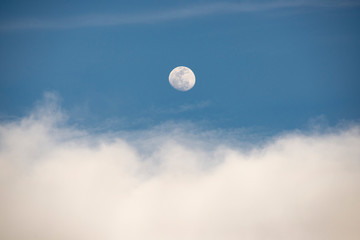 ciel bleu et nuages blancs avec une pleine lune blanche. blue sky and white clouds with a full white moon.