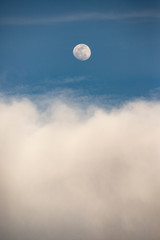 ciel bleu et nuages blancs avec une pleine lune blanche. blue sky and white clouds with a full white moon.