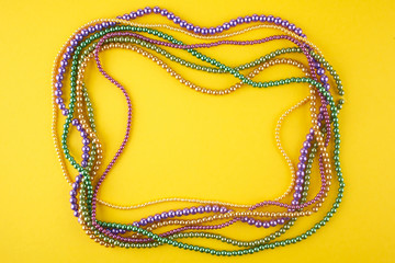 Mardi Gras beads background with place for text. Top view