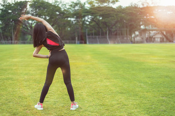 Women warm up before exercising outdoors during the morning hours in the park.
