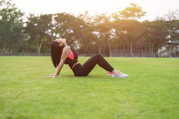 Women warm up before exercising outdoors during the morning hours in the park.