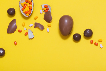 Easter yellow background with chocolatte eggs and  candy