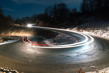 lights of cars on the bend of the road at night