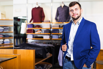 man choosing casual jacket in fashion store