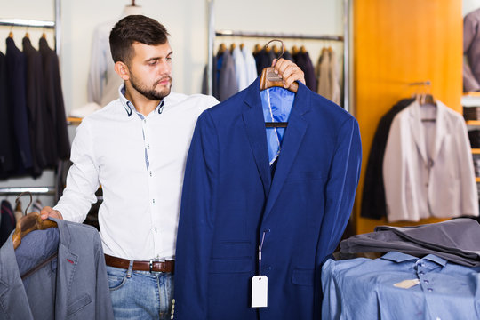 Handsome man customer choosing jacket