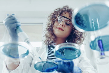 Young scientist working at the lab. Young female scientist doing some research. - Powered by Adobe