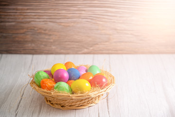 Beautiful group Easter eggs in the spring of easter day, red eggs, blue, purple and yellow in Wooden basket on the table background wood