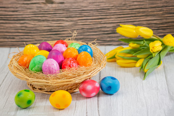 Obraz na płótnie Canvas Beautiful group Easter eggs in the spring of easter day, red eggs, blue, purple and yellow in Wooden basket on the table background wood.
