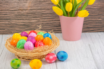 Fototapeta na wymiar Beautiful group Easter eggs in the spring of easter day, red eggs, blue, purple and yellow in Wooden basket on the table background wood.