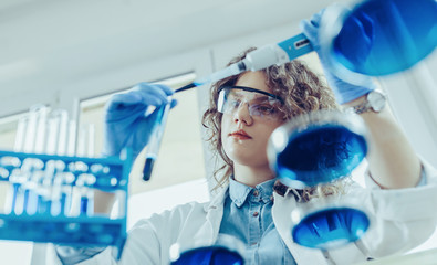 Young scientist working at the lab. Young female scientist doing some research.