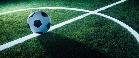 Soccer ball on glowing lines on a field at night