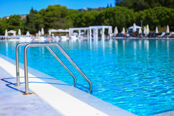 Ladder to go down to swimming pool on outdoor playgound zone of the hotel. Sunshine and clear blue...
