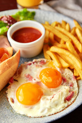 English breakfast including egg , french fries, salad, toasts and sauce.