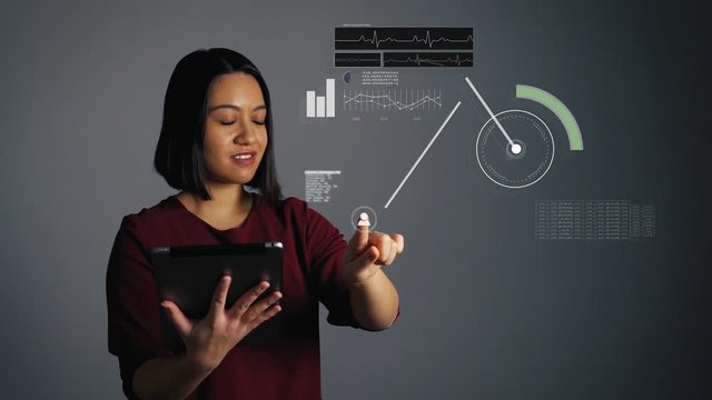 Young woman holds a tablet and uses a digital hologram touchscreen to take a look at their health data