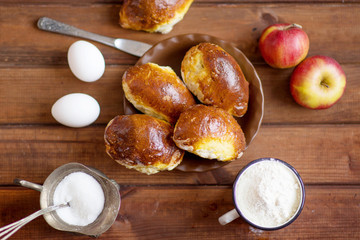 homemade apple pies, yeast pies on a wooden table with eggs and milk in the village, village pies with apple filling