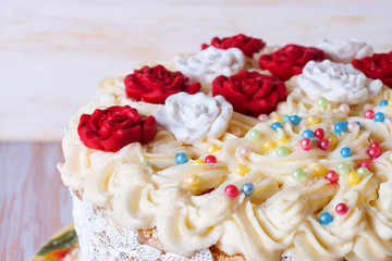 white cake with cream and red roses on white dish