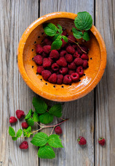 Raspberries  in a yellow bowl on the wooden table
