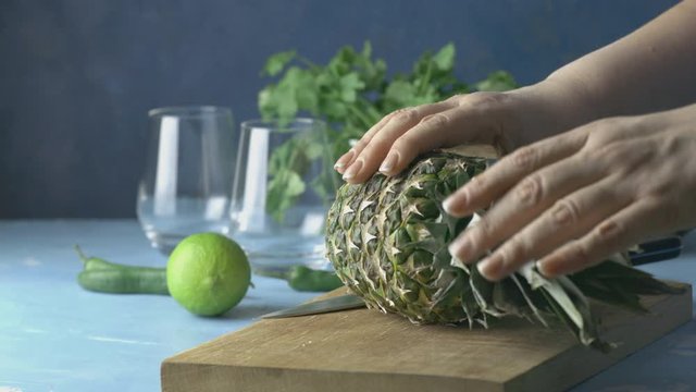 Woman prepared pineapple for Spicy pineapple jalapeno mezcalita or margarita for Cinco de Mayo is a refreshing cocktail made with pineapple, cilantro, jalapeno and mexican distilled alcoholic beverage