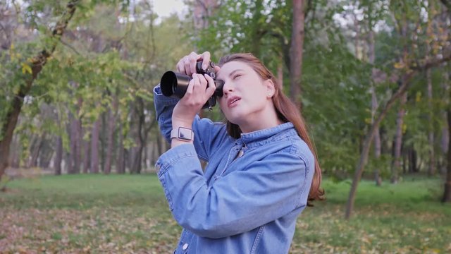 A professional photographer while working outdoors. Autumn Forest, Caucasian woman content creator