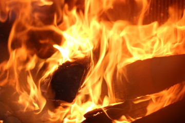 Fire burning in fireplace stock photo. Beautiful rich flame. A fire burns in a glass fireplace, radiates heat from burning logs in the fireplace 