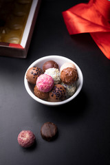 Gourmet chocolates in a bowl on a dark background. Valentine's Day, love, romantic moment.