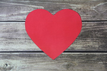 Fototapeta na wymiar Red heart made of paper symbol of love on a background of wooden boards