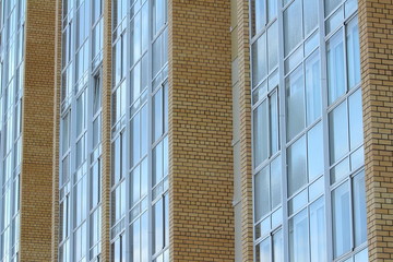 Obraz premium Plastic windows in a modern tiled brick high-rise house.