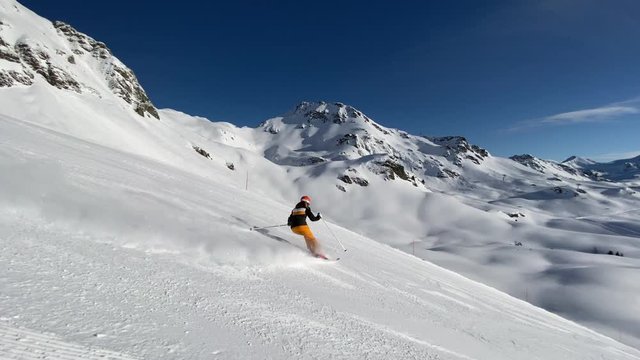 4K slow motion video woman skiing on ski slope on sunny winter day in beautiful alpine mountains