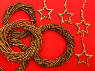 Vier dekorative, hölzerne Kränze und Sterne auf einem roten Hintergrund