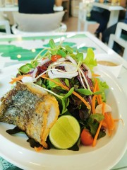 grilled salmon salad VEGAN with fresh lime and organic vegetable on white dish