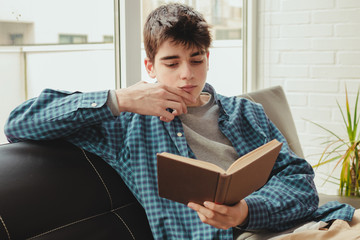 young teenage boy reading or studying at home