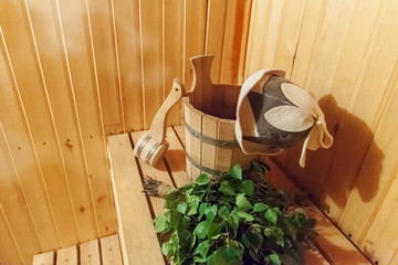 Fototapeta na wymiar Interior details Finnish sauna steam room bathhouse with traditional sauna accessories basin birch broom scoop felt hat