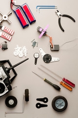 Vertical composition drone workshop table, with aero model radio control (RC), drone parts, and tools on the gray worktable. Top view