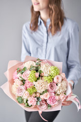 European floral shop. Beautiful bouquet of mixed flowers in womans hands. the work of the florist at a flower shop. Delivery fresh cut flower.