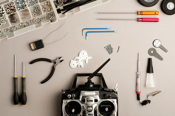 Drone workshop table, with radio control station, drone parts, and tools on the gray worktable. Top view
