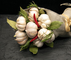 A beautiful bouquet of fresh garlic with red pepper and Bay leaves . Wrapped in coarse matting and tied with Linden bast.