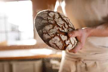 Bäcker presentiert bio Brot in der Backstube